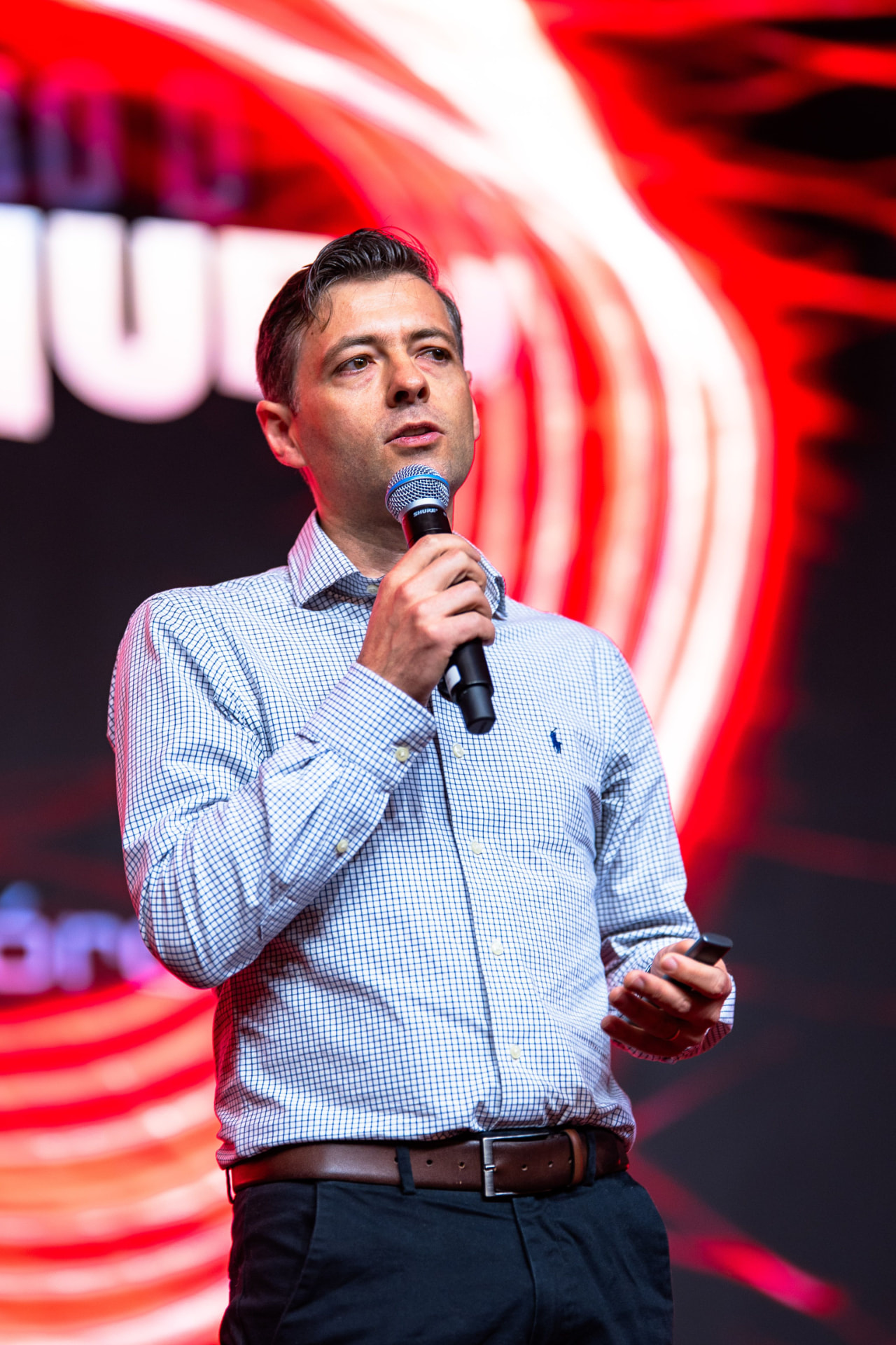 Gabriel Utzig apresentando uma palestra, com microfone na mão